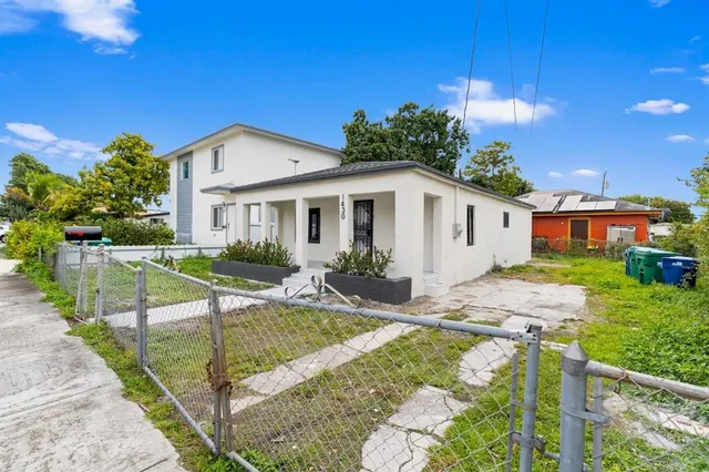 a view of a house with backyard and sitting area