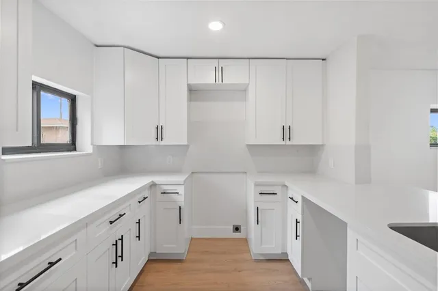 a kitchen with white cabinets and refrigerator