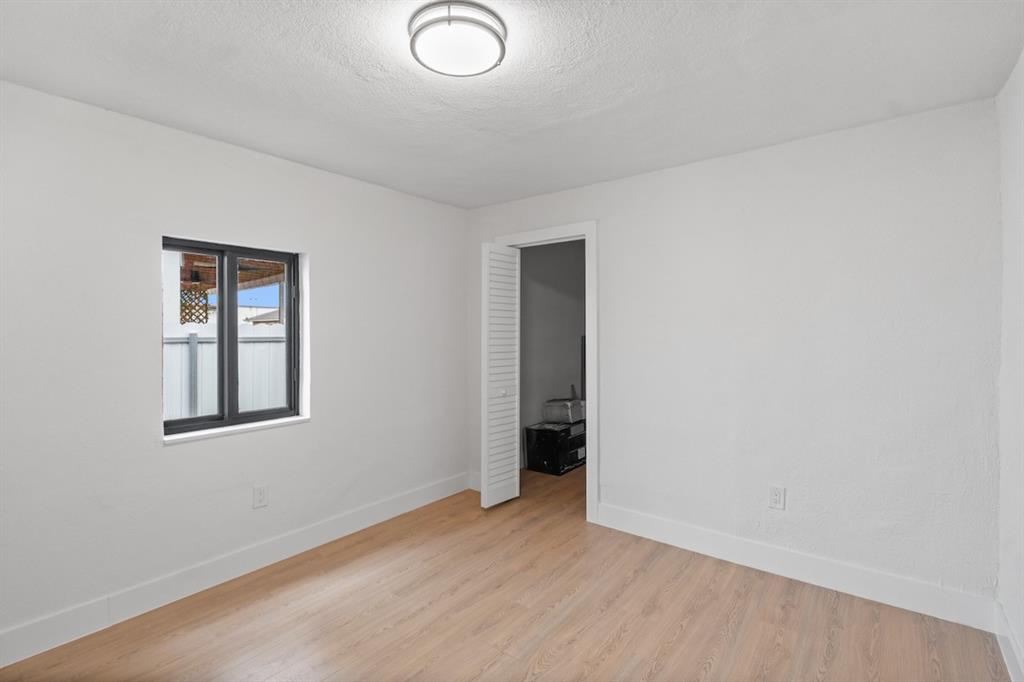 1430 Northwest 74th Street Miami, FL 33147 - Photo 17 of 29 an empty room with wooden floor and windows