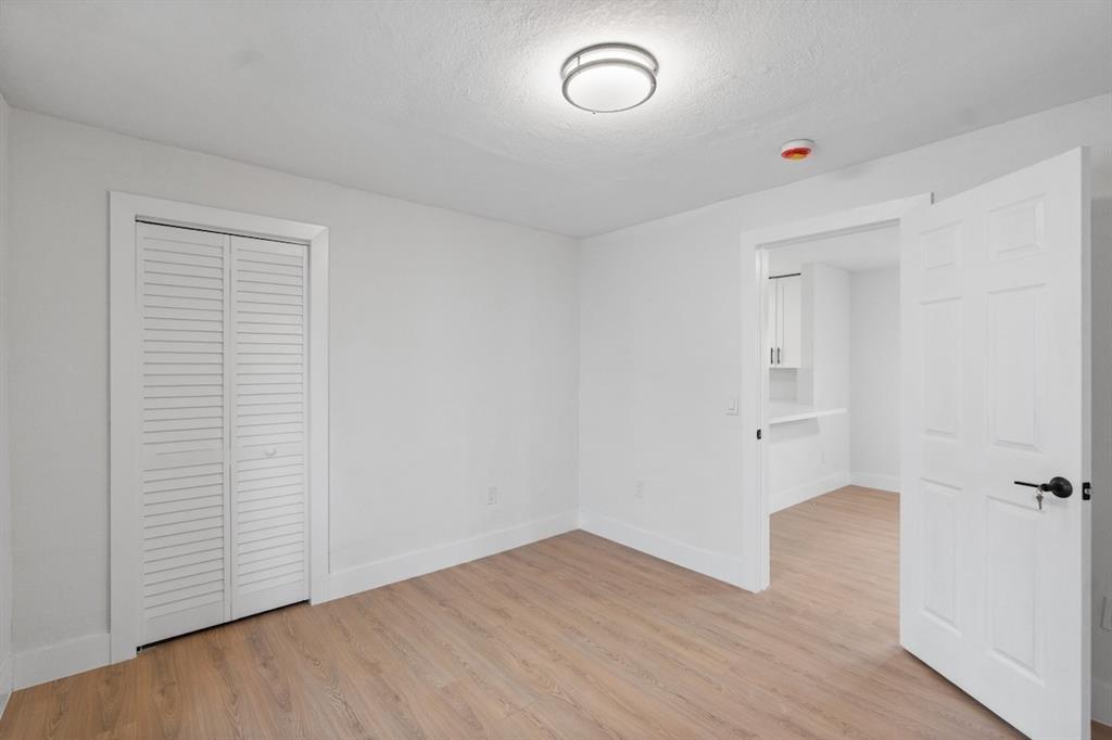 1430 Northwest 74th Street Miami, FL 33147 - Photo 19 of 29 an empty room with wooden floor and windows