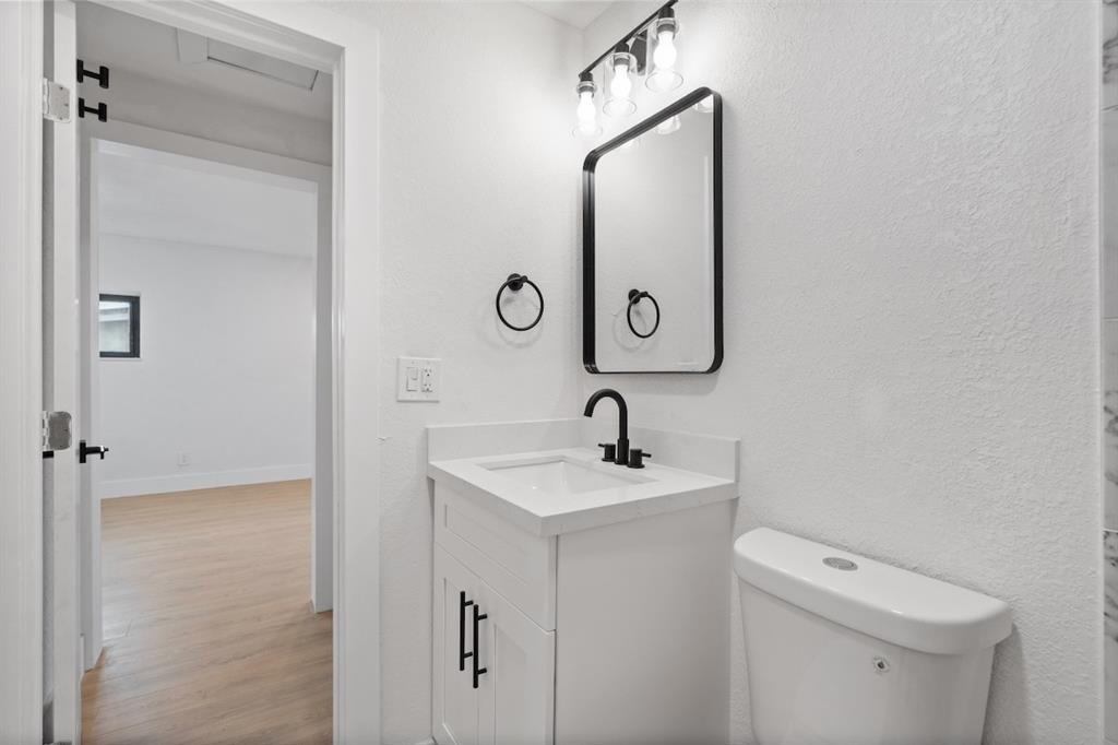 1430 Northwest 74th Street Miami, FL 33147 - Photo 21 of 29 a bathroom with a toilet sink and mirror