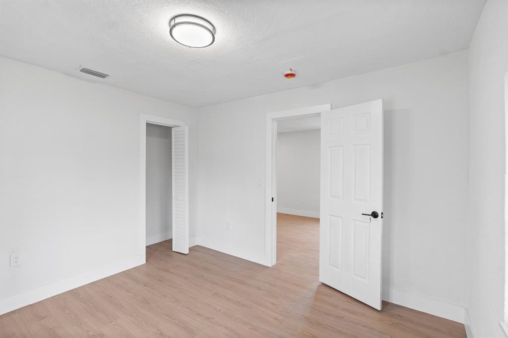 1430 Northwest 74th Street Miami, FL 33147 - Photo 23 of 29 an empty room with wooden floor and window