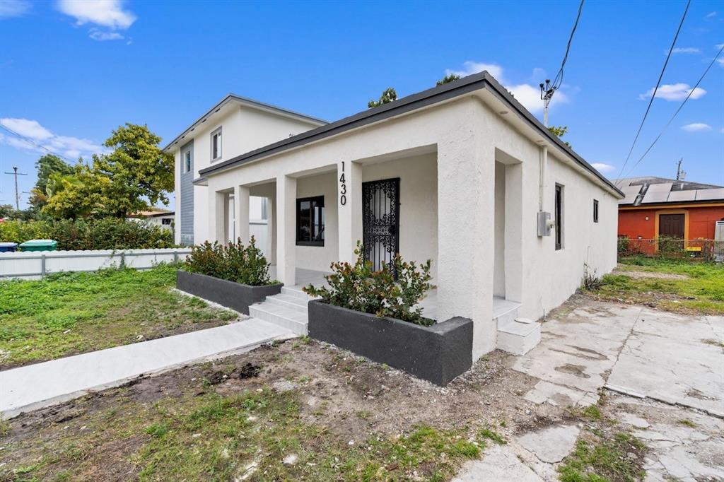 1430 Northwest 74th Street Miami, FL 33147 - Photo 3 of 29 a front view of a house with a yard