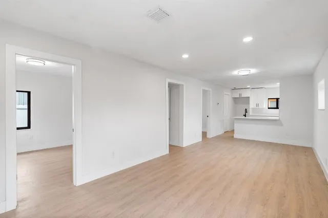 a view of a big room with wooden floor and windows