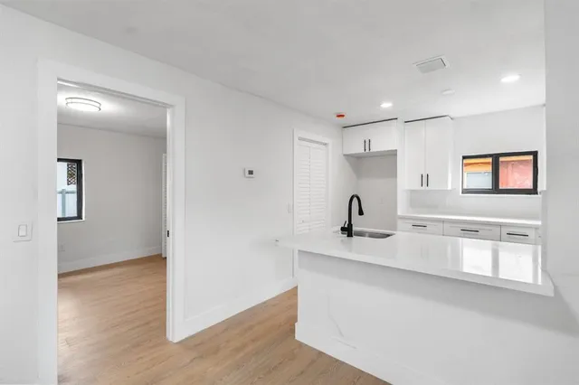 a view of a kitchen with a sink a refrigerator and window