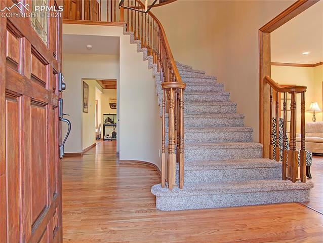 735 Winding Hills Road Monument, CO 80132 - Photo 2 of 42 Entry with hardwood floors, vaulted ceiling, and circular staircase