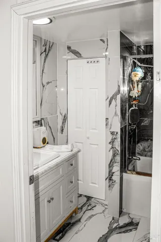 a room with a walk in closet and mirror