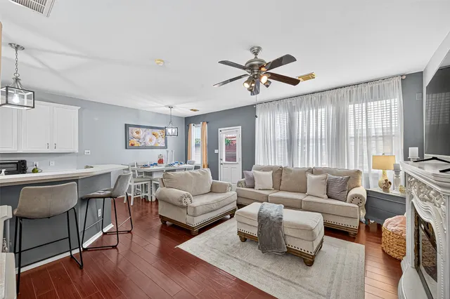 a dining room with furniture a chandelier and wooden floor