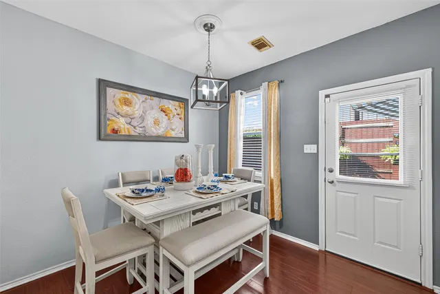 a kitchen with a dining table chairs and white cabinets