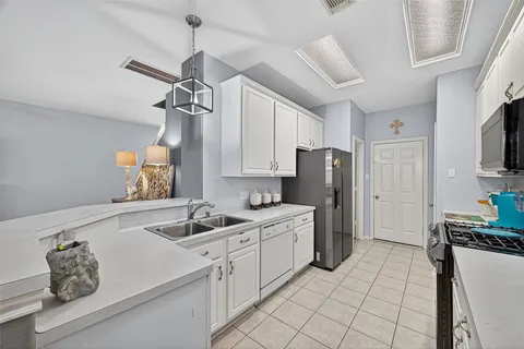 a kitchen with white cabinets and stainless steel appliances