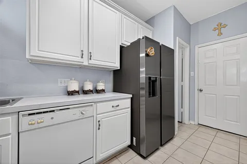 a kitchen with stainless steel appliances granite countertop a stove top oven a sink dishwasher and white cabinets