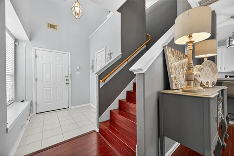 a living room with chair a clock on wall and a table