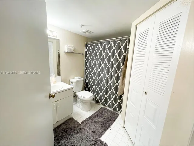 a white toilet sitting next to a shower curtain