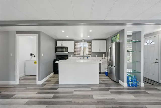 a view of kitchen with refrigerator and microwave