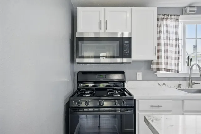 a stove top oven sitting inside of a kitchen