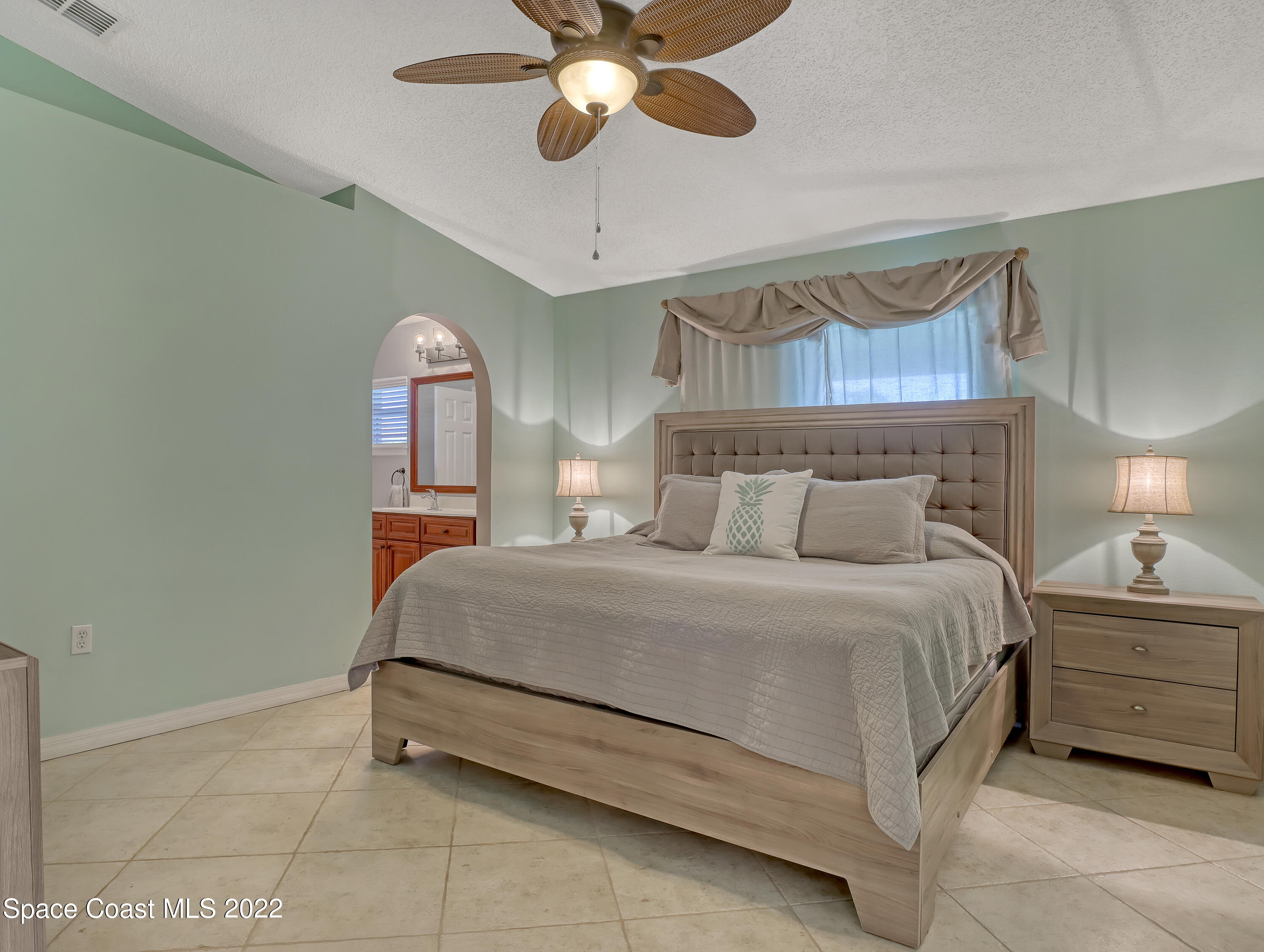 4920 Spinet Drive Melbourne, FL 32940 - Photo 17 of 44 a bedroom with a bed and a chandelier
