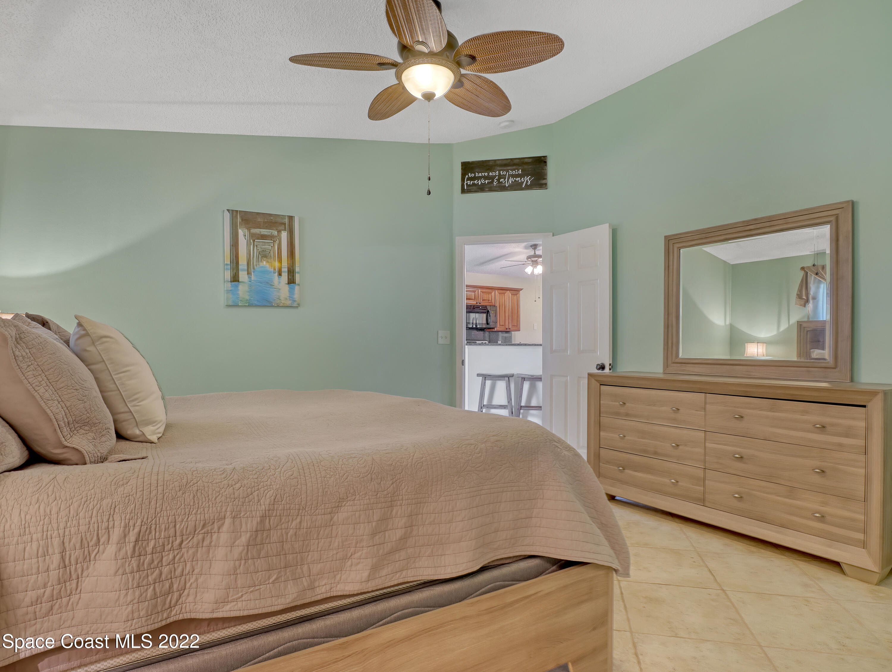 4920 Spinet Drive Melbourne, FL 32940 - Photo 18 of 44 a bedroom with a bed a chandelier and a dresser
