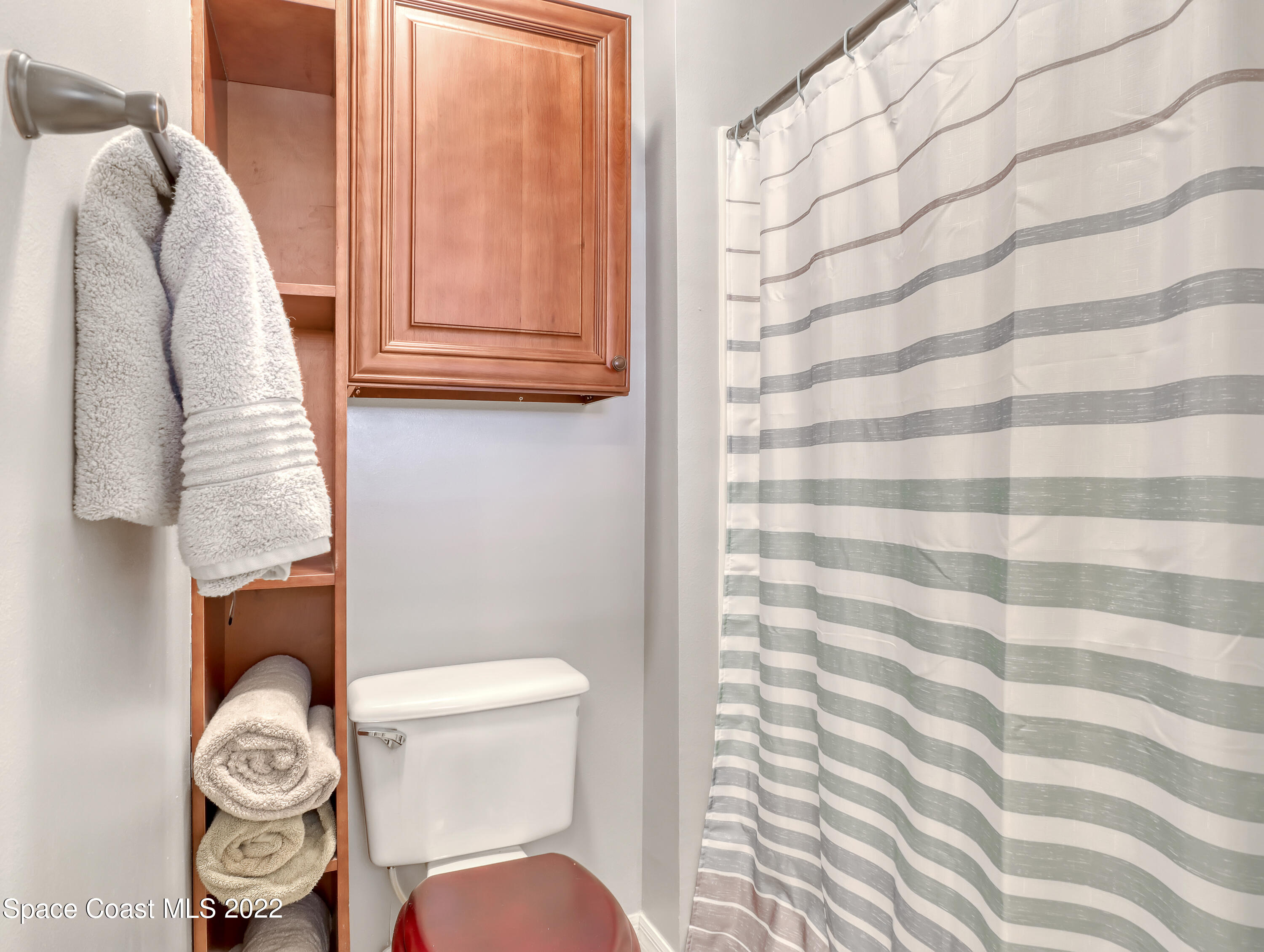 4920 Spinet Drive Melbourne, FL 32940 - Photo 19 of 44 a bathroom with a toilet and a shower curtain