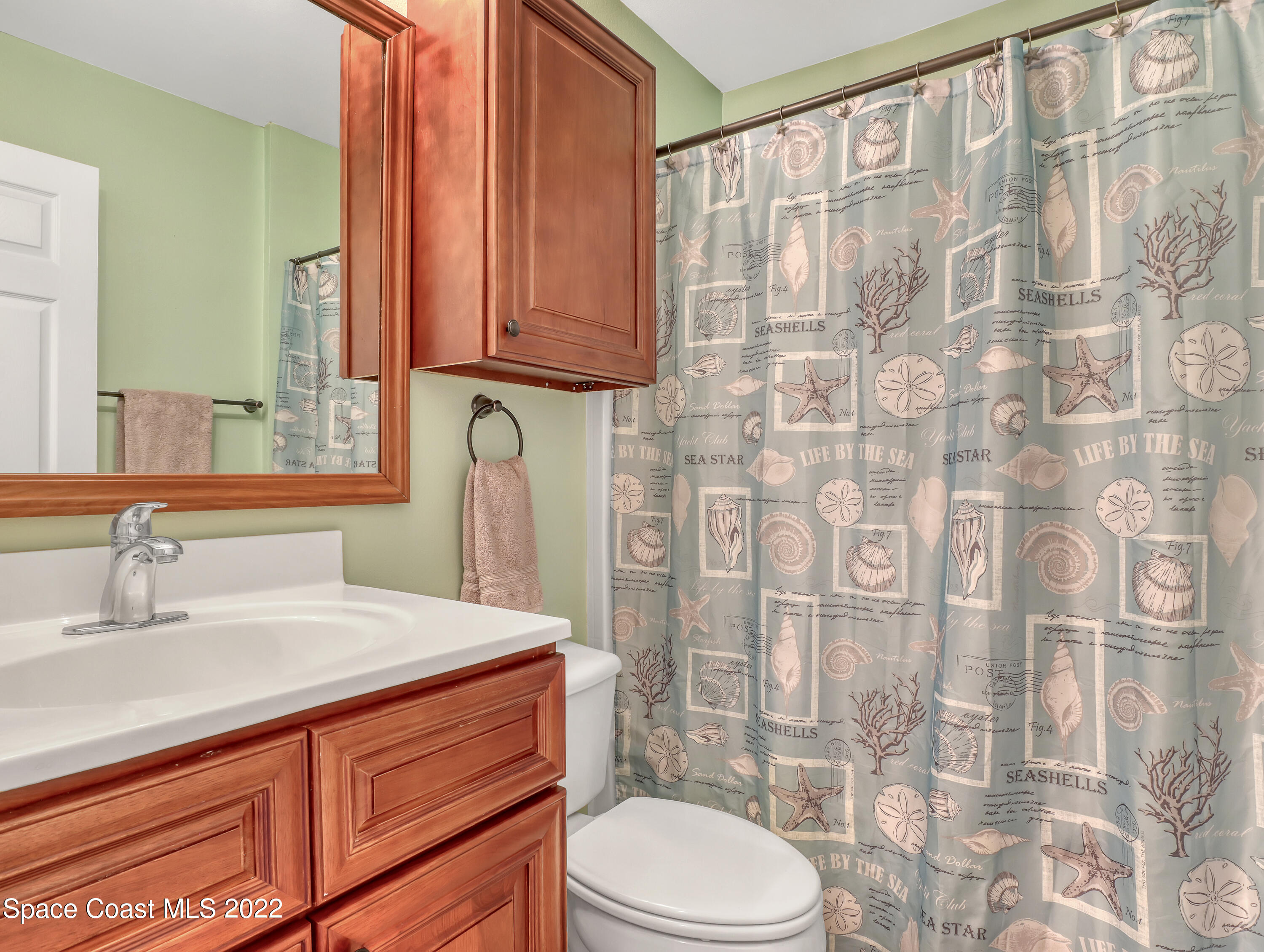 4920 Spinet Drive Melbourne, FL 32940 - Photo 25 of 44 a bathroom with a sink a toilet and shower curtain