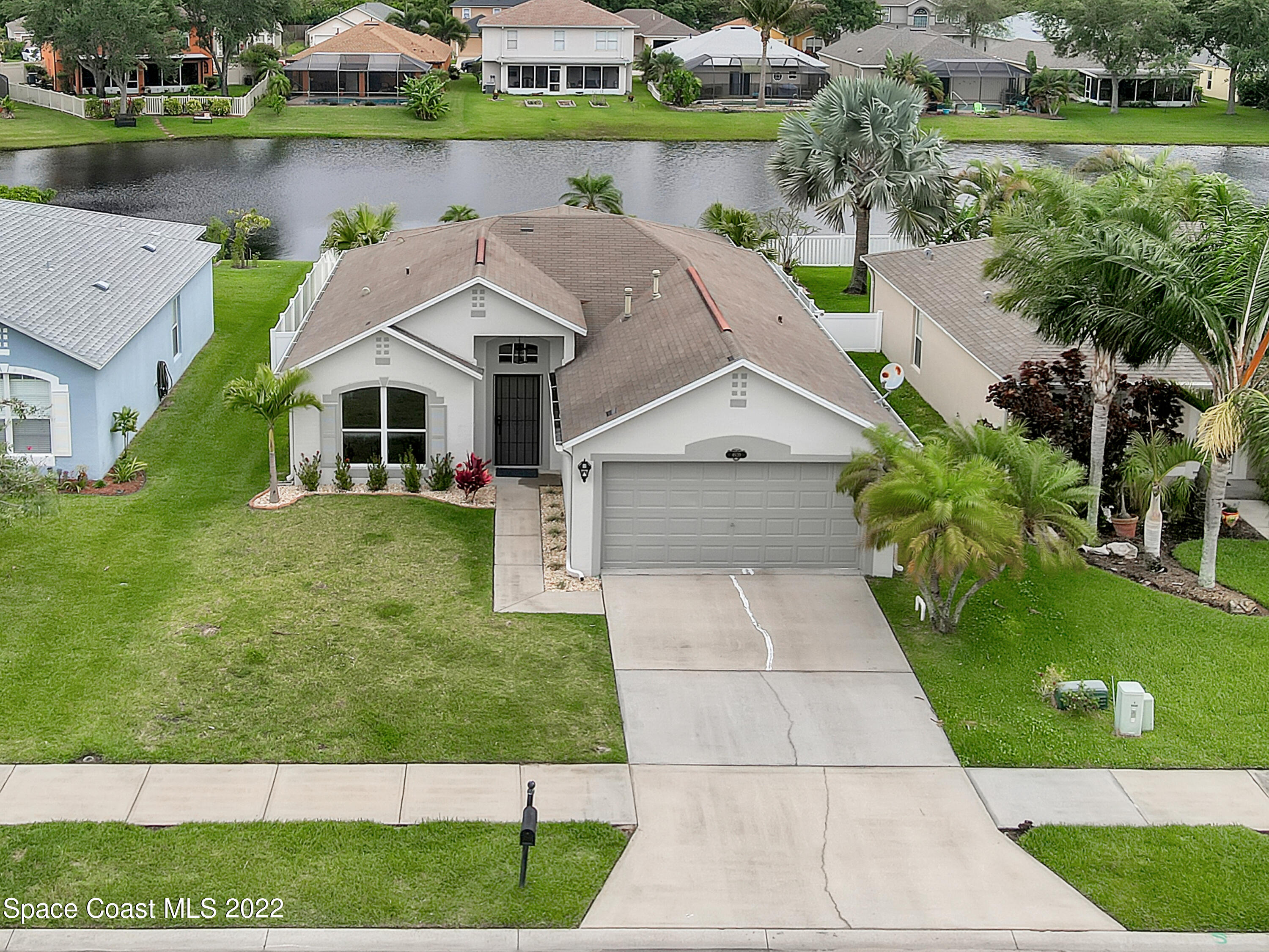 4920 Spinet Drive Melbourne, FL 32940 - Photo 39 of 44 a white house with a yard and plants