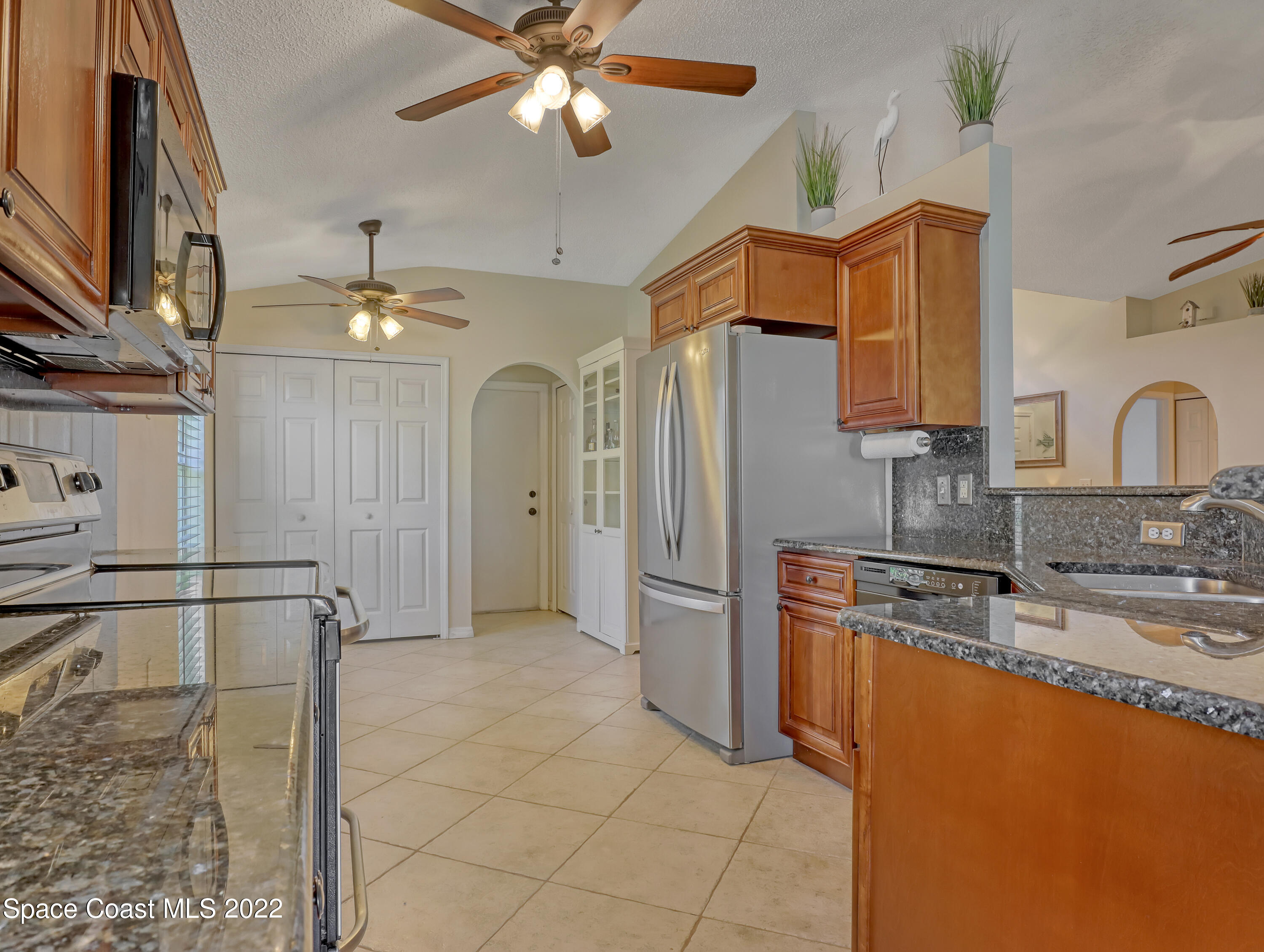 4920 Spinet Drive Melbourne, FL 32940 - Photo 7 of 44 a kitchen with stainless steel appliances granite countertop a refrigerator and a sink