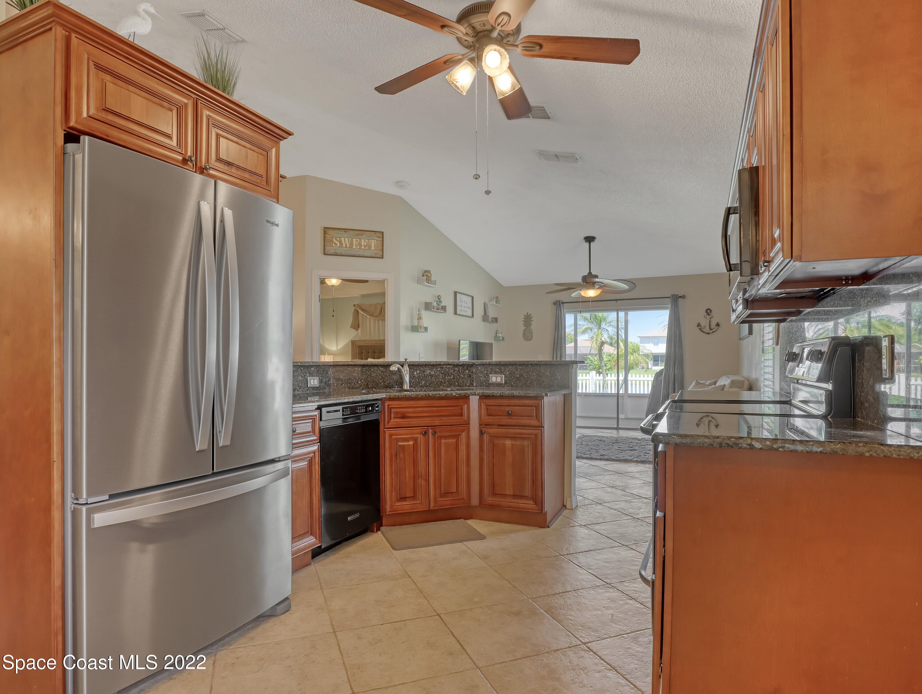 4920 Spinet Drive Melbourne, FL 32940 - Photo 8 of 44 a kitchen with stainless steel appliances granite countertop a refrigerator a oven a sink with a dining table and chairs