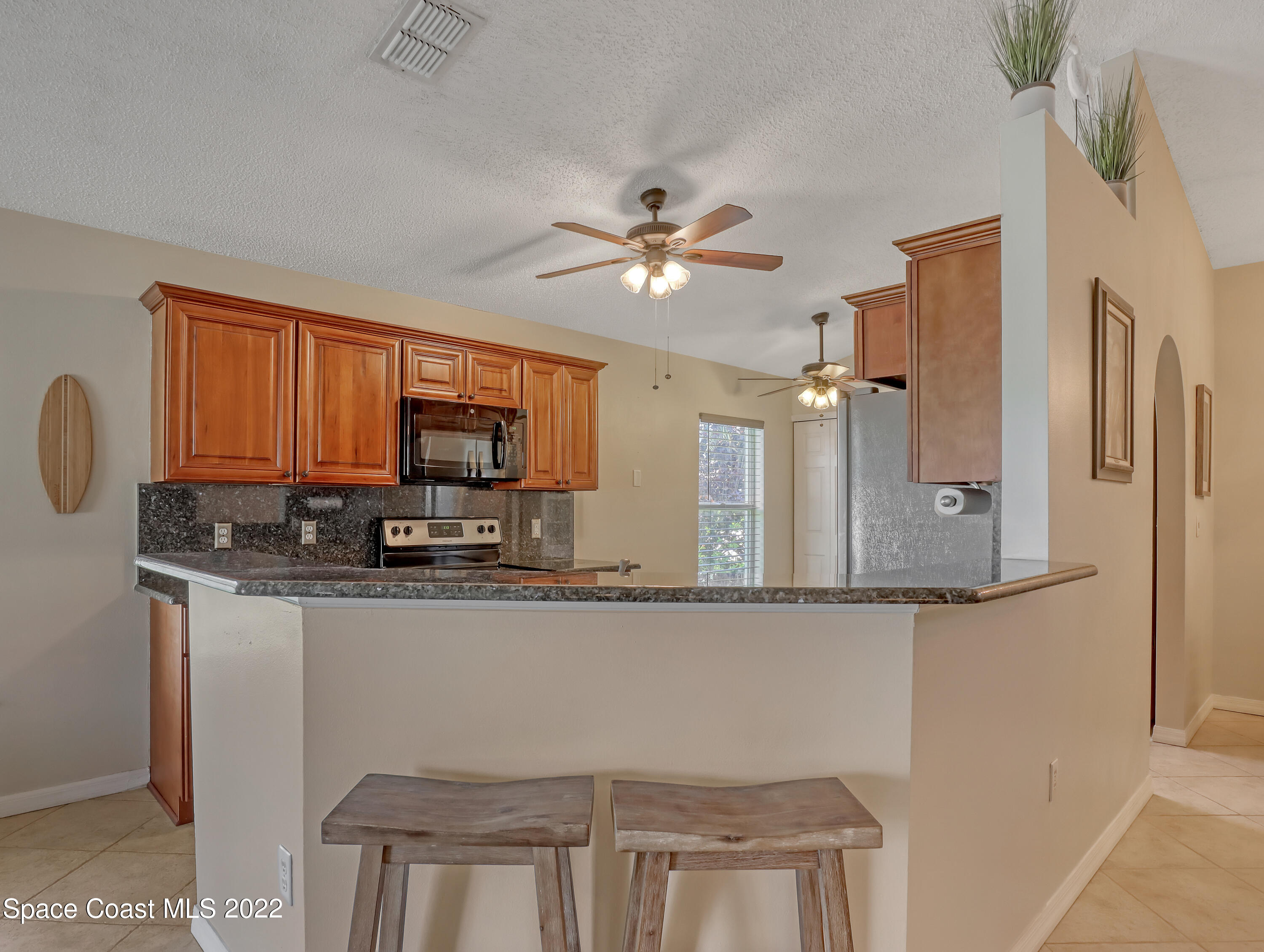 4920 Spinet Drive Melbourne, FL 32940 - Photo 10 of 44 a kitchen with stainless steel appliances granite countertop a sink and a refrigerator