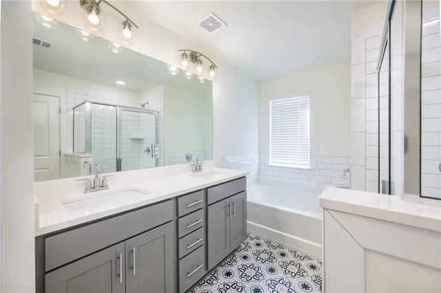 a bathroom with a sink double vanity mirror and a bathtub