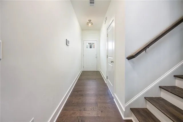 a view of a hallway with wooden floor and staircase