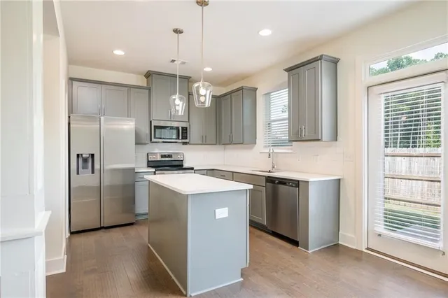 a kitchen with kitchen island a sink stainless steel appliances and window