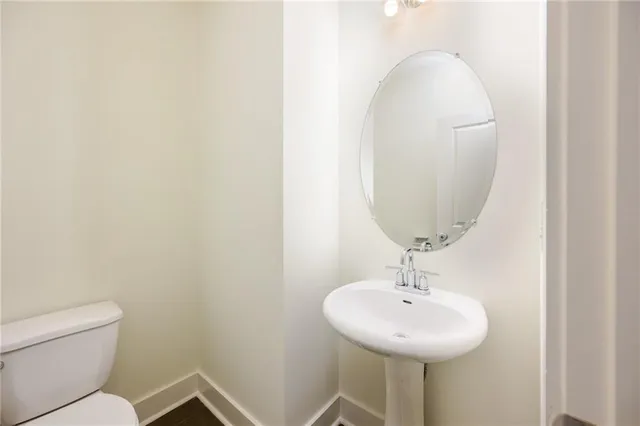 a bathroom with a sink a toilet and a mirror