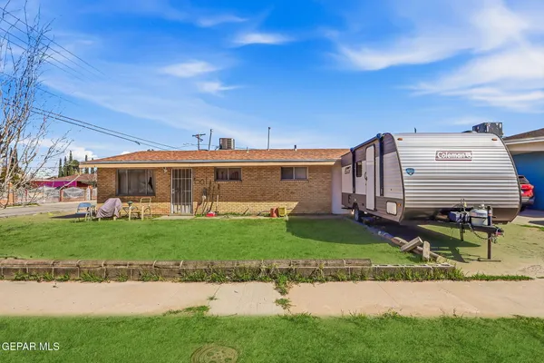 a front view of a house with a garden and yard