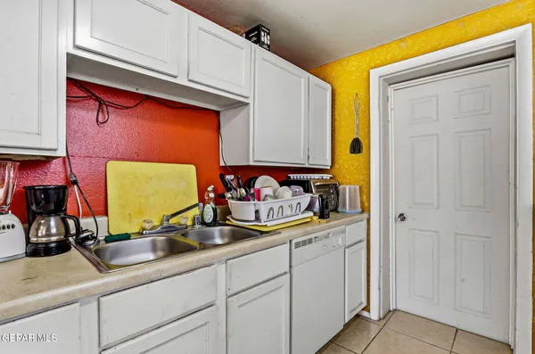 a room with stainless steel appliances granite countertop a sink and a cabinets