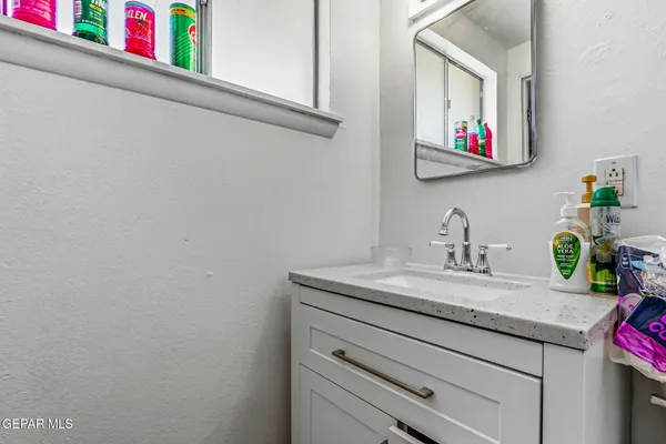 a bathroom with a granite countertop sink and a mirror