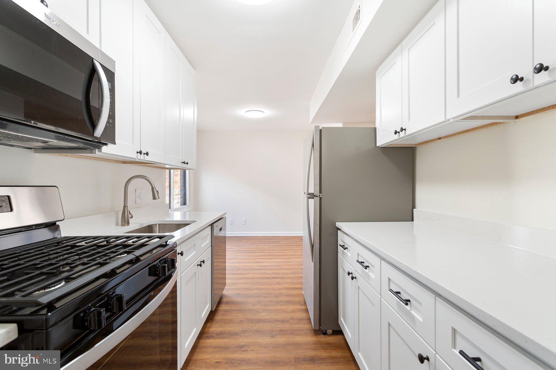 11234 Cherry Hill Road, Unit 304 Beltsville, MD 20705 - Photo 15 of 28 a kitchen with stainless steel appliances granite countertop a sink stove and refrigerator