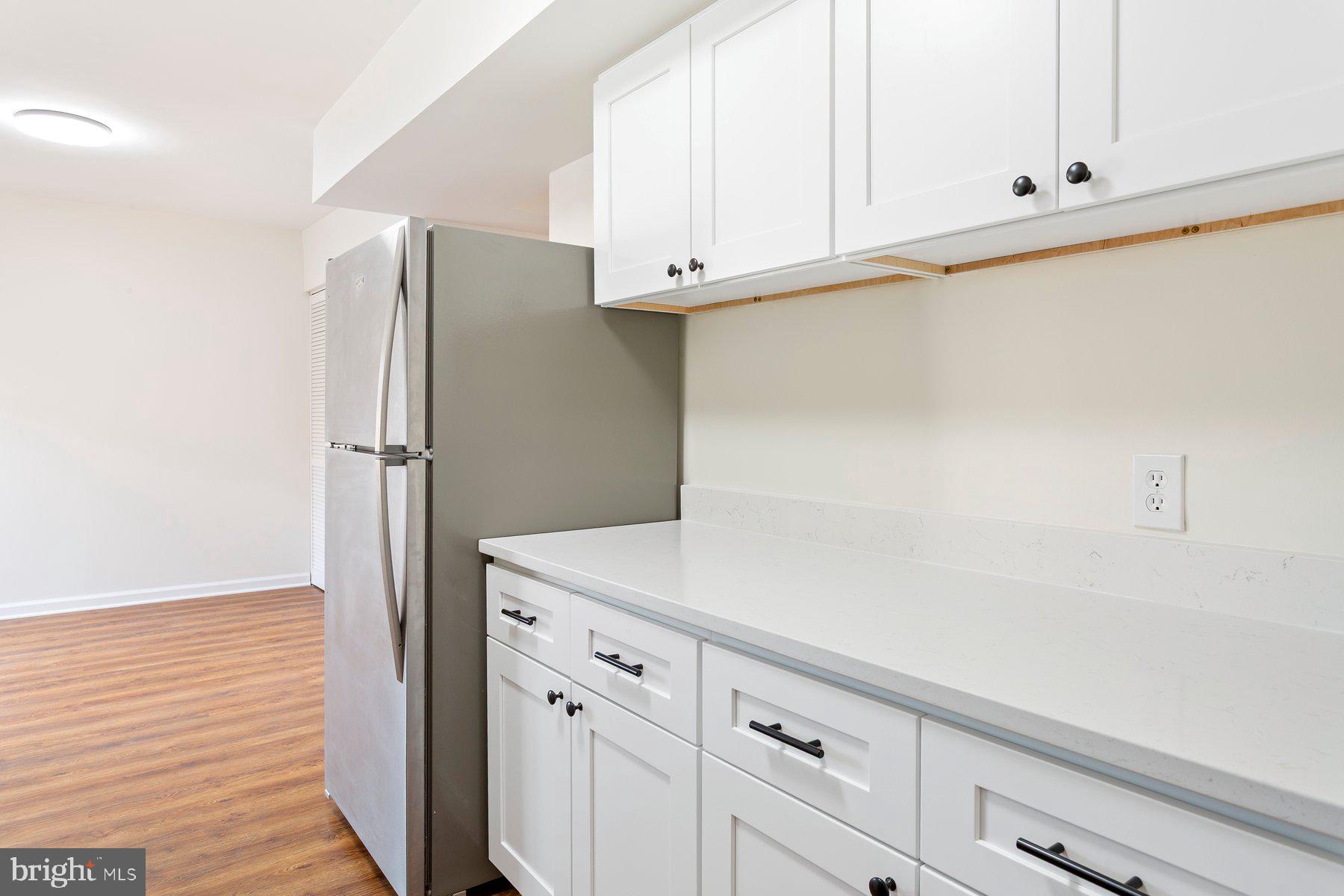 11234 Cherry Hill Road, Unit 304 Beltsville, MD 20705 - Photo 16 of 28 a kitchen with cabinets and a refrigerator