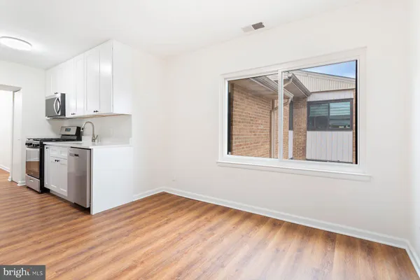 a view of a kitchen with wooden floor and a window