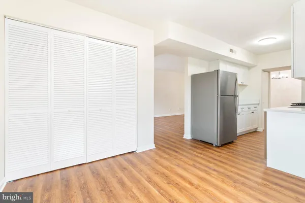 a view of kitchen with refrigerator and wooden floor