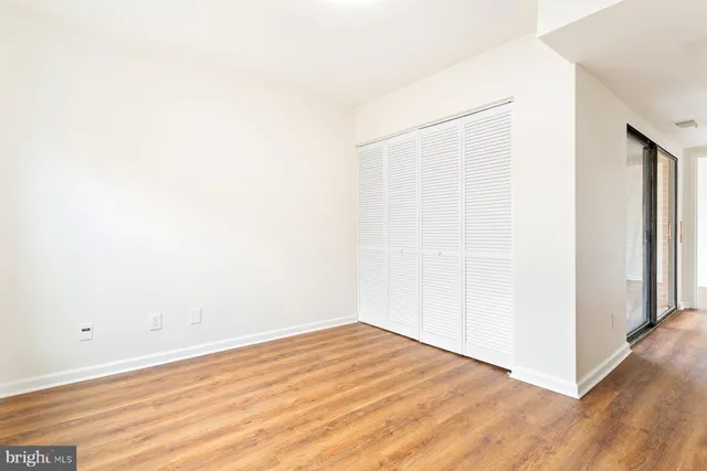 a view of empty room with wooden floor