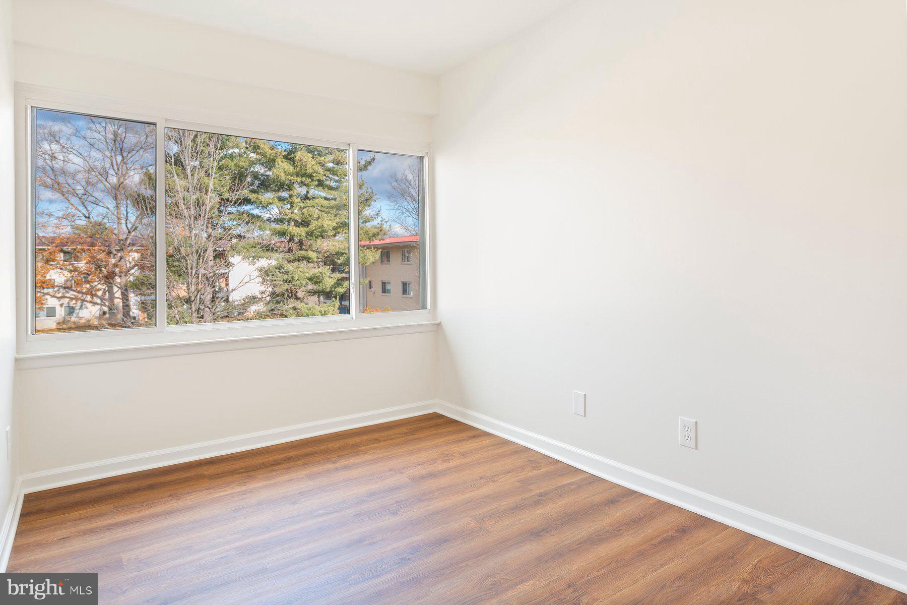 11234 Cherry Hill Road, Unit 304 Beltsville, MD 20705 - Photo 22 of 28 an empty room with wooden floor and windows
