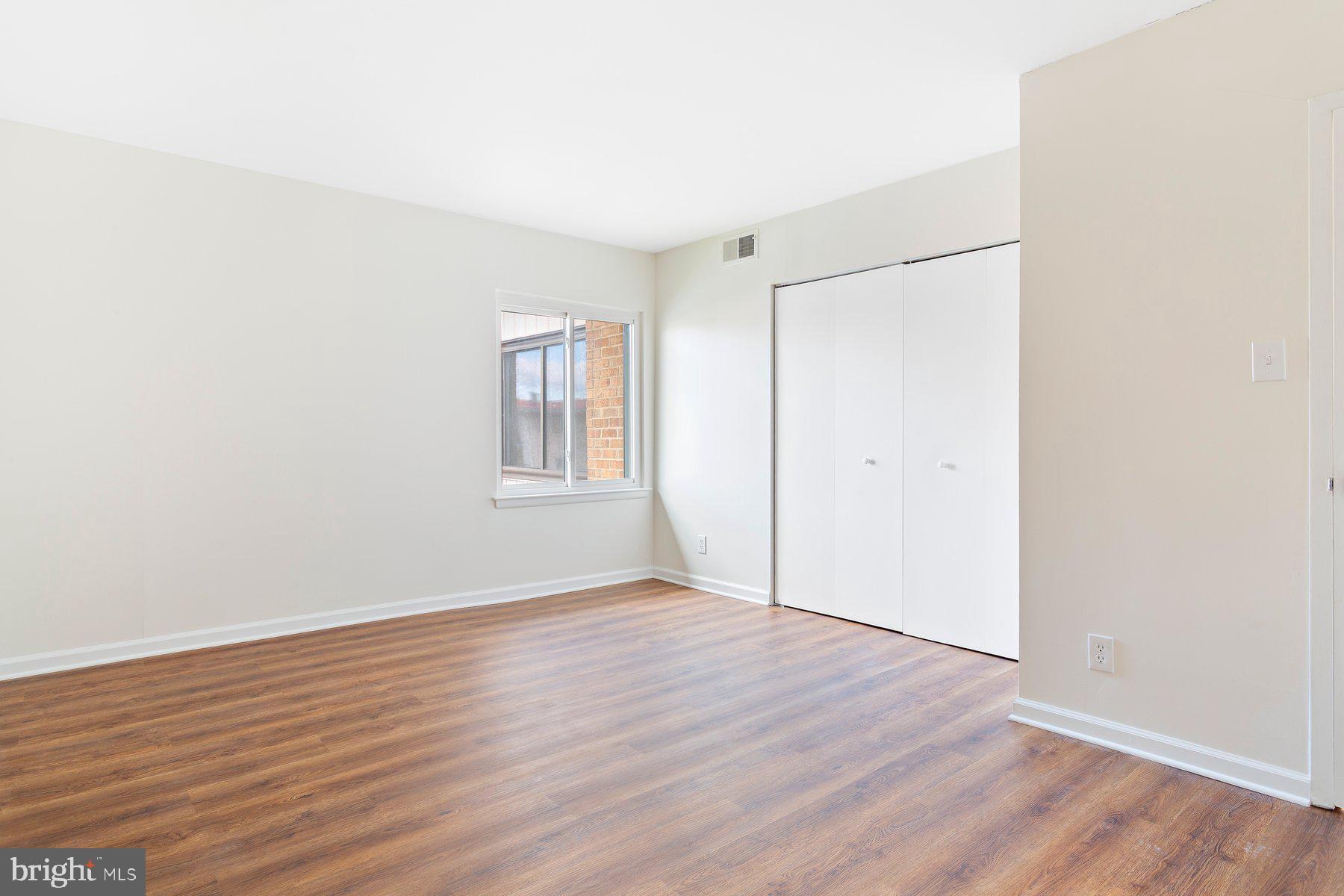 11234 Cherry Hill Road, Unit 304 Beltsville, MD 20705 - Photo 24 of 28 an empty room with wooden floor and windows