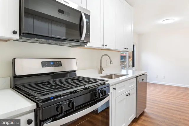 a stove top oven sitting inside of a kitchen