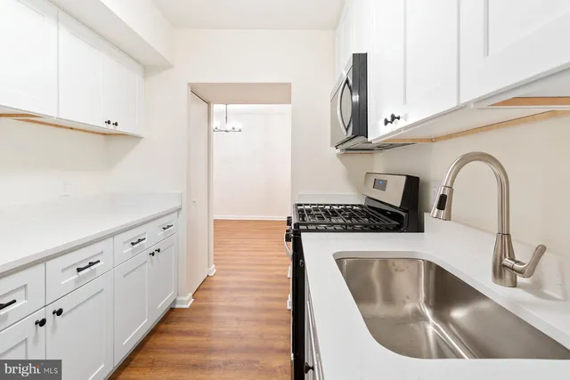 a kitchen with sink a stove and cabinets