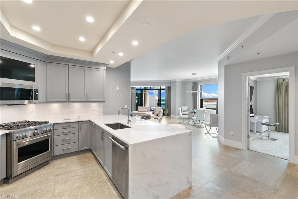 9123 Strada Place, Unit 7510 Naples, FL 34108 - Photo 13 of 38 Kitchen with gray cabinets, a peninsula, light stone countertops, stainless steel appliances, and recessed lighting