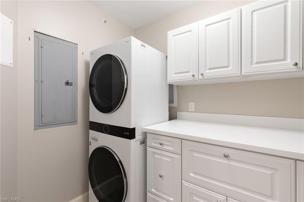 9123 Strada Place, Unit 7510 Naples, FL 34108 - Photo 23 of 38 Laundry area with stacked washer and dryer, electric panel, and cabinet space