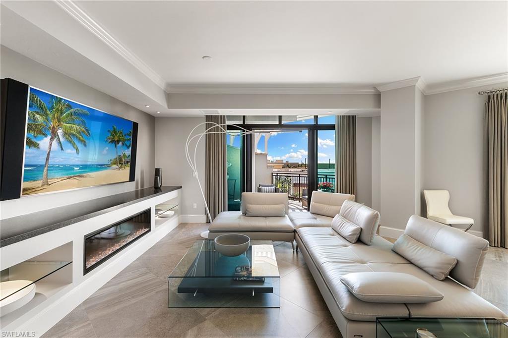9123 Strada Place, Unit 7510 Naples, FL 34108 - Photo 4 of 38 Living room with crown molding and a glass covered fireplace