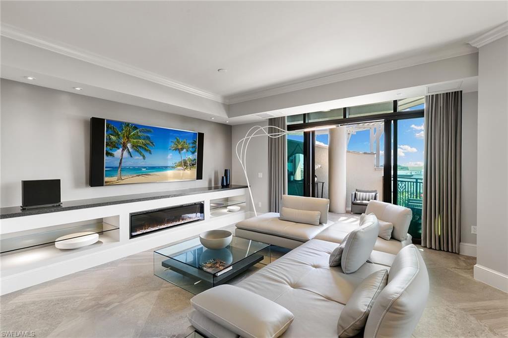 9123 Strada Place, Unit 7510 Naples, FL 34108 - Photo 5 of 38 Living area with a glass covered fireplace, crown molding, and recessed lighting