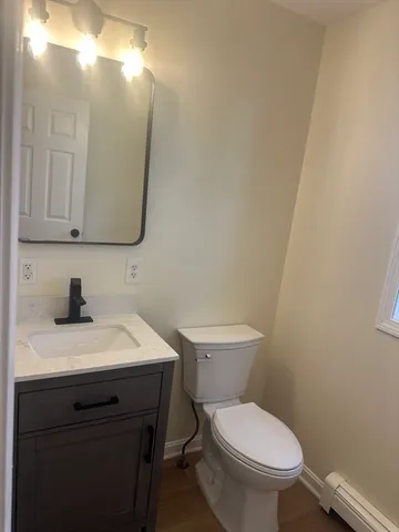 a bathroom with a toilet a sink and mirror