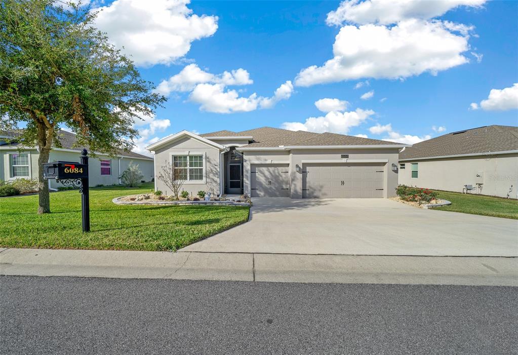 a front view of a house with a garden and trees