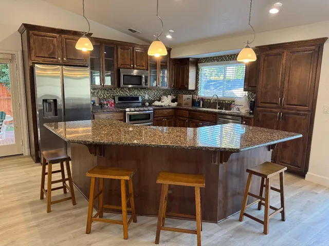 a kitchen with a table chairs refrigerator and wooden cabinets
